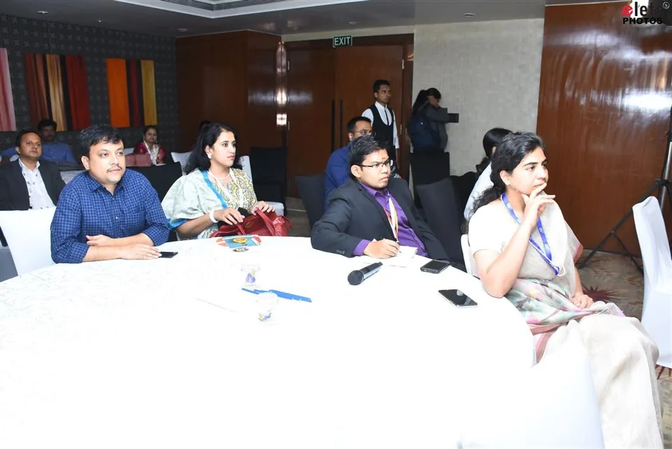 Delegates seated at a round table during a session