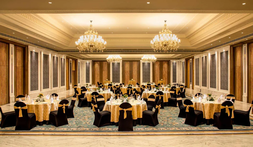 A banquet hall at ITC Kakatiya, with crystal chandeliers over dressed round tables
